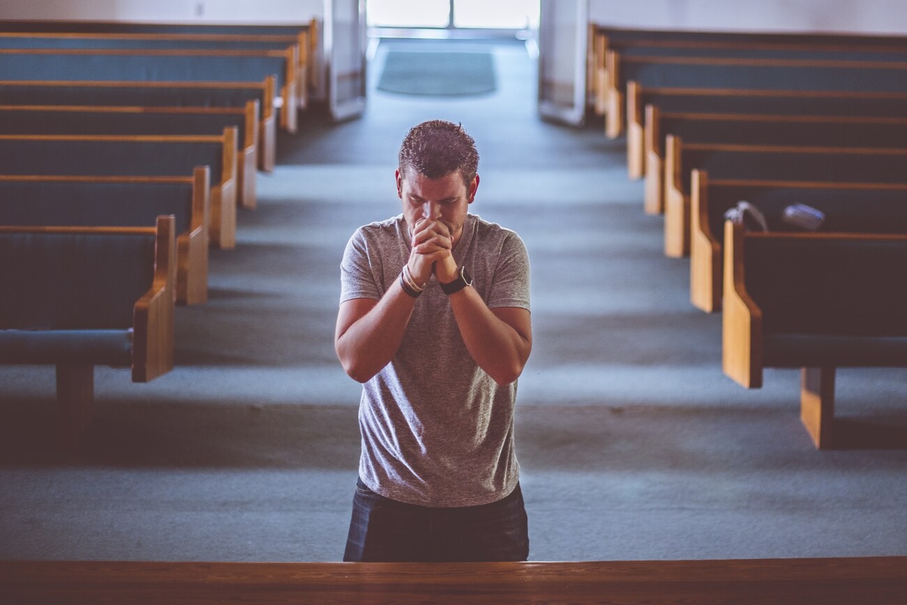 礼拝で祈りをささげる男性